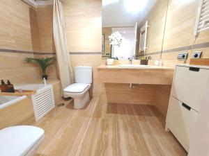a bathroom with a toilet and a sink and a tub at Apartamento de Lujo en urbanización privada in Águilas