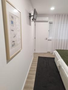 um quarto com uma cama e uma fotografia na parede em BUS STATION Suites & Studios em Coimbra