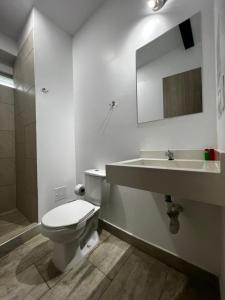 bagno con servizi igienici, lavandino e specchio di Carriqui Underground a Pereira