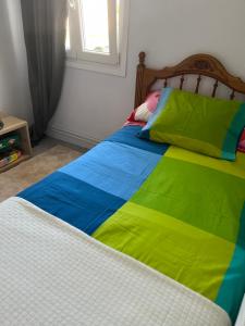 Una cama con una manta de colores encima. en Viviendas uso turístico REME I en Foz