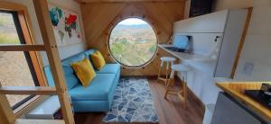 a tiny house with a blue couch and a window at Mini Casa Villa De Leyva in Sáchica