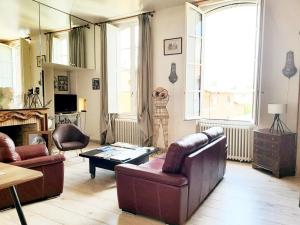 ein Wohnzimmer mit einem Sofa, Stühlen und einem Tisch in der Unterkunft PIED A TERRE DE CHARME in Albi