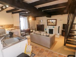 a kitchen and living room with a couch and a fireplace at Lilac Cottage in Paignton