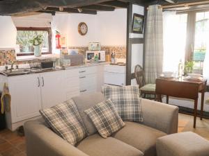 a living room with a couch and a kitchen at Lilac Cottage in Paignton