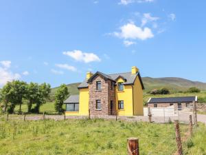 een geel huis in het midden van een veld bij Lack Cottage in Tralee