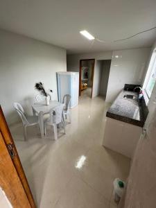 ein Wohnzimmer mit einem weißen Tisch und Stühlen in der Unterkunft Residencial Casa Grande - Apto 03 in Santa Cruz Cabrália