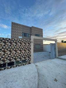 um edifício de tijolos com um portão e uma garagem em Residencial Casa Grande - Apto 03 em Santa Cruz Cabrália