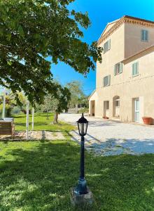 a street light in the grass in front of a building at L'Antica Colombaia; Apartment with private entrance in Ostra