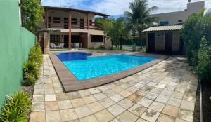 a swimming pool in front of a house at Maravilhosa casa Ponta de Serrambi in Porto De Galinhas