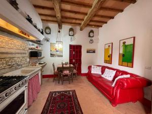 sala de estar con sofá rojo y mesa en Casa Beccofino, en Pienza