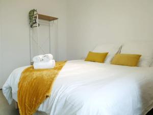 a bedroom with a large white bed with yellow pillows at Le Bohème in Pamiers