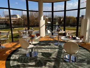 a room with tables and chairs and large windows at Residhome Neuilly Bords De Marne in Neuilly-Plaisance +13 photos