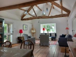 a living room with wooden floors and exposed beams at Gesail Barn and Farmhouse in Machynlleth