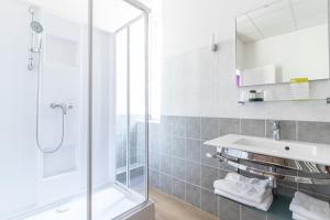 a bathroom with a shower and a sink at Hôtel De La Plage in Le Chambon-sur-Lignon