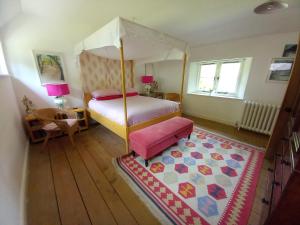a bedroom with a canopy bed and a rug at Gesail Barn and Farmhouse in Machynlleth
