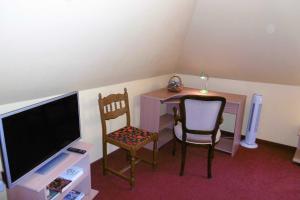 een kamer met een bureau, 2 stoelen en een televisie bij Ruegen_Fewo 62 in Putbus