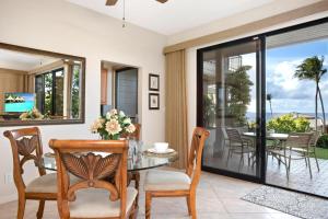 a dining room with a glass table and chairs at K B M Resorts Kapalua Bay Villas KBV 17G4 bed Ocean Front in Kapalua