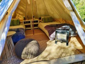 une tente avec 2 lits et un panneau. dans l'établissement Gaia Double bell tent, à Swellendam