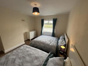 a small bedroom with two beds and a window at The Moorlands in Dundalk
