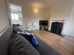 a living room with a couch and a fireplace at The Moorlands in Dundalk