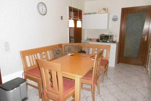 cocina y comedor con mesa de madera y sillas en Ruegen_Fewo 68, en Natzevitz