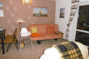 una sala de estar con un sofá naranja en una habitación en Ruegen_Fewo 68, en Natzevitz