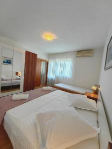 1 cama blanca grande en un dormitorio con espejo en Apartment Laura on the first floor, en Makarska