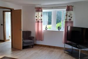 a living room with a television and a window at Coolams in Ingleton 
