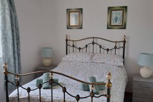 a bed in a bedroom with two lamps and two tables at Coolams in Ingleton