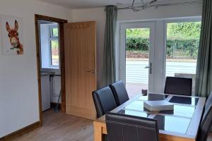 a dining room with a table and chairs and a door at Coolams in Ingleton