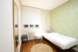 サン・セバスティアンにあるGo Donosti Moneoのベッドと窓が備わる小さな客室です。