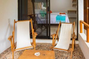 two chairs and a table in front of a door at Casa Yoo Bigu Mazunte in Mazunte
