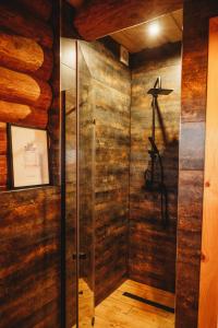 Cette chambre dispose de murs en bois et d'une douche à l'italienne. dans l'établissement WILLA ALPEJSKA z prywatnym jacuzzi, à Konin