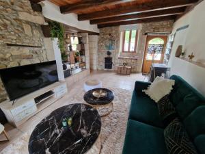 a living room with a couch and a tv at Maison de vacances in Vanxains