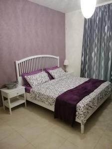 Un dormitorio con una cama con sábanas y almohadas púrpuras. en Dead Sea Jordan Sea View Samarah Resort Traveler Award 2024 winner, en Sowayma
