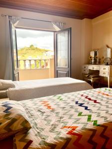 a bedroom with two beds and a large window at Casa da Pedra Guest House in Torres Vedras