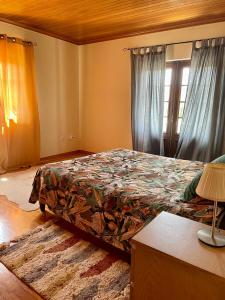 a bedroom with a bed with a colorful comforter at Casa da Pedra Guest House in Torres Vedras