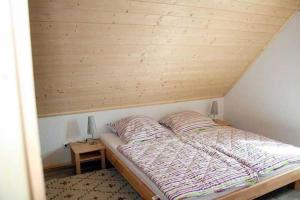 a bed in a room with a wooden ceiling at Ruegen_Fewo 292 in Ummanz
