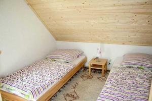 two beds in a room with a wooden ceiling at Ruegen_Fewo 292 in Ummanz