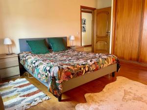 a bedroom with a large bed with green pillows at Casa da Pedra Guest House in Torres Vedras