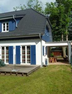 a blue and white house with a wooden deck at Ruegen_Fewo 292 in Ummanz