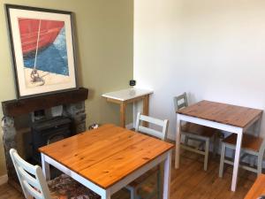 a dining room with two tables and a fireplace at The Old Post Office House BnB in Balmacara