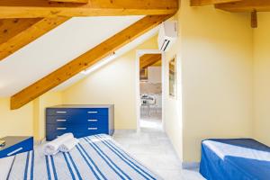 Schlafzimmer im Dachgeschoss mit einem Bett und einer Treppe in der Unterkunft Star House in Marina dʼAndora