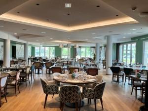 a dining room with tables and chairs in a building at Domitys L'Orangerie in Sens