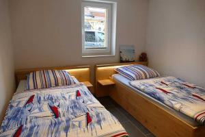 two twin beds in a room with a window at Ruegen_Fewo 279_2 in Kasnevitz +4 photos