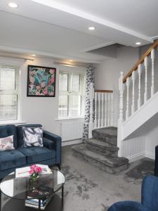 sala de estar con sofá azul y escaleras en Picturesque 3 bed house, Killala, en Killala