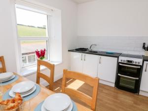 a kitchen with a table with chairs and a stove at Thornlea View in Hope-Cove