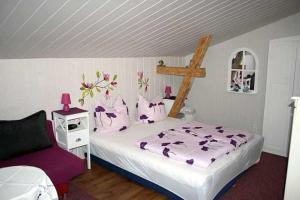 a bedroom with a large bed with purple sheets at Ruegen_Fewo 241 in Putbus