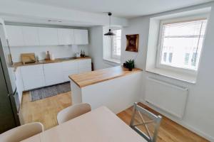 a kitchen with white cabinets and a table and a window at Apartment Laizor in Staszów