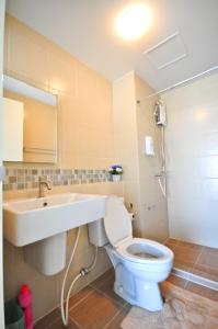 ホアヒンにあるBaan Peang Ploen Huahinの白いトイレと洗面台のあるバスルーム